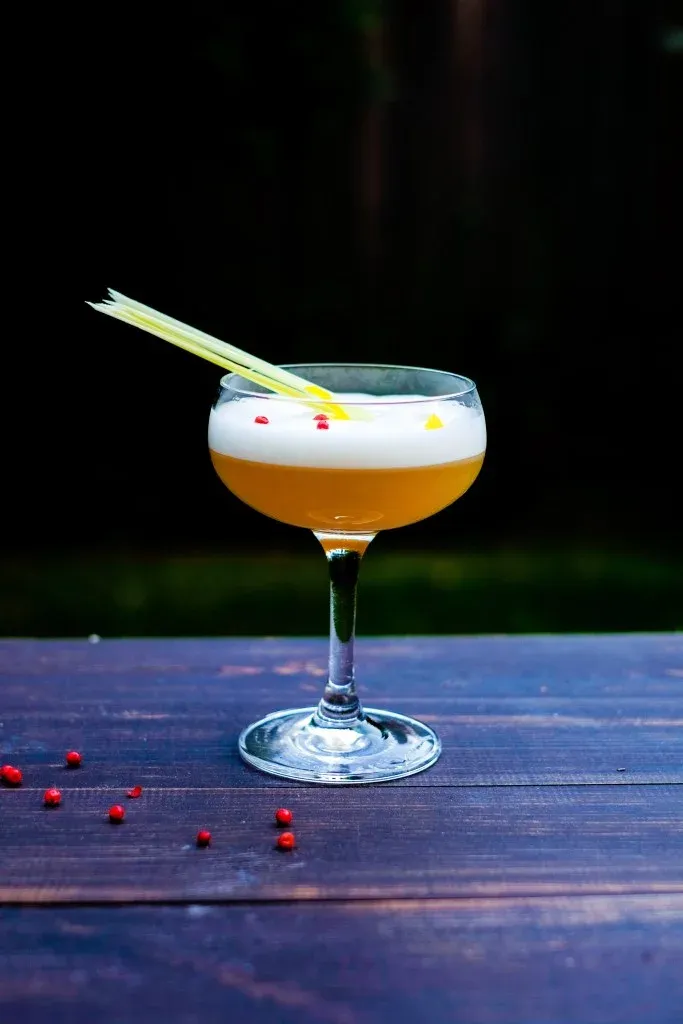 Siam Sour cocktail with lemongrass and pink peppercorn garnish