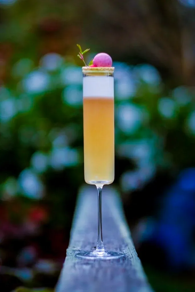 An Efflorescence of Spring cocktail with macaron and bonbon garnish