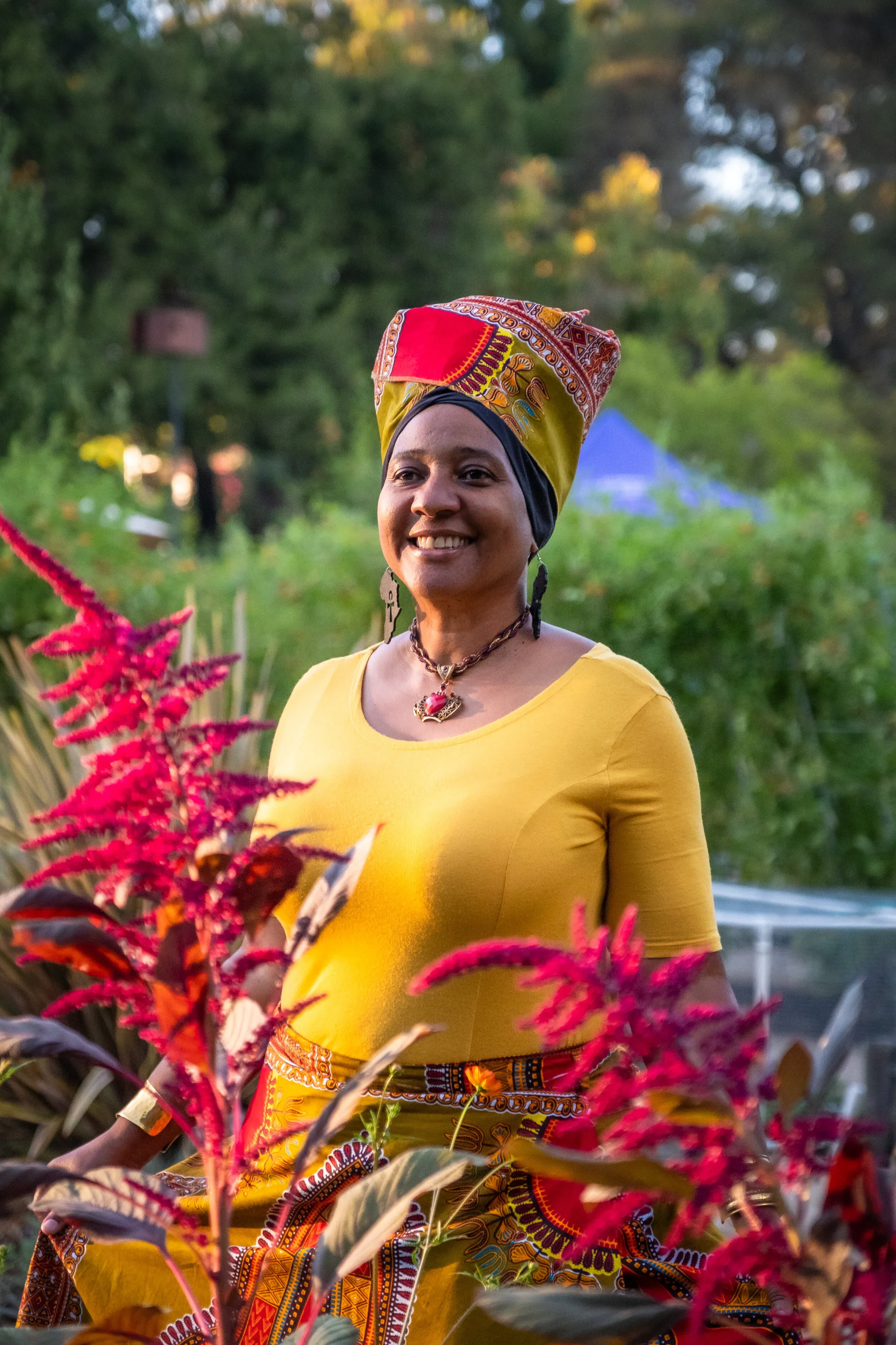 Thandiwe Jennifer Lyons in her garden wearing a vibrant headwrap