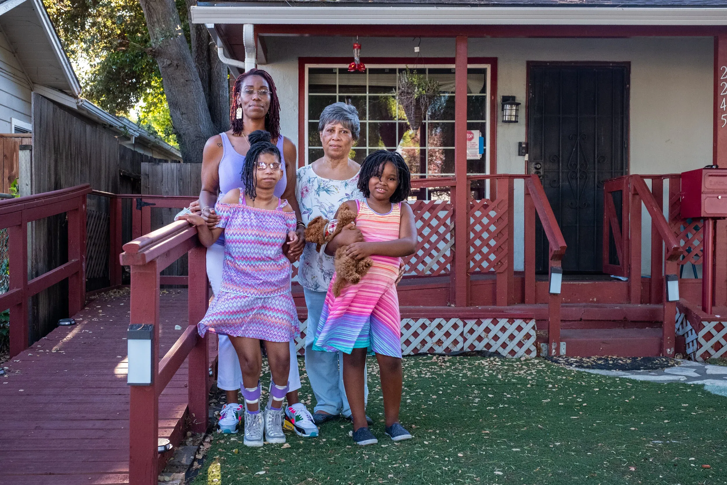 The Dowden family — Nyla, her mother Caslida, and daughters Detsiy'ah and Deliy'ah — in front of their home