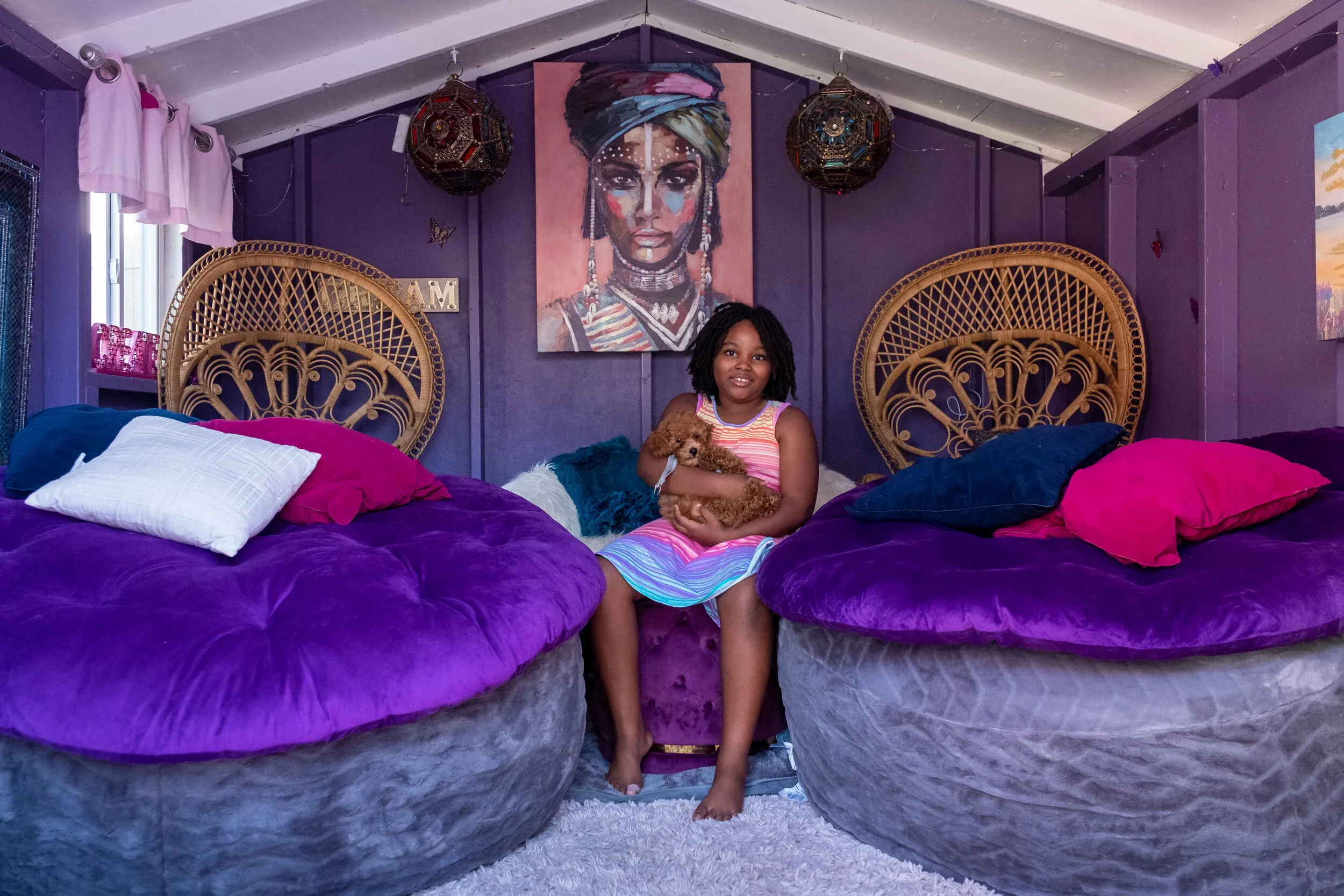 Deliy'ah in her purple playhouse decorated by her mother, holding her puppy Nassir