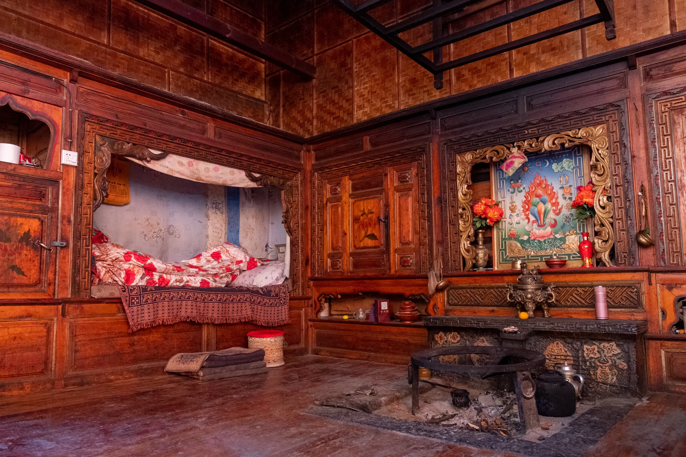 Traditional Mosuo kitchen with curing meat and Chairman Mao poster