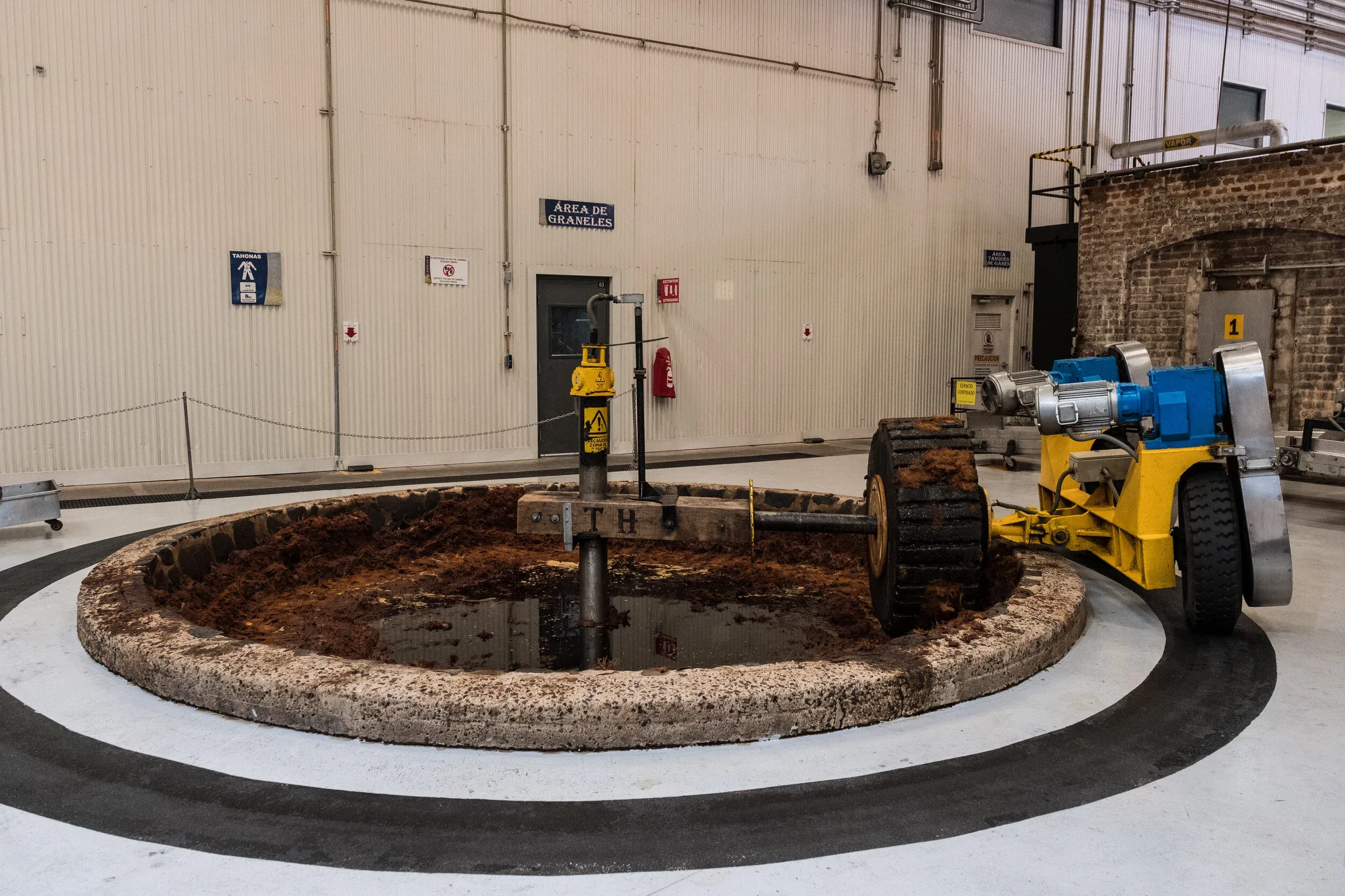 Tahona stone wheel crushing agave